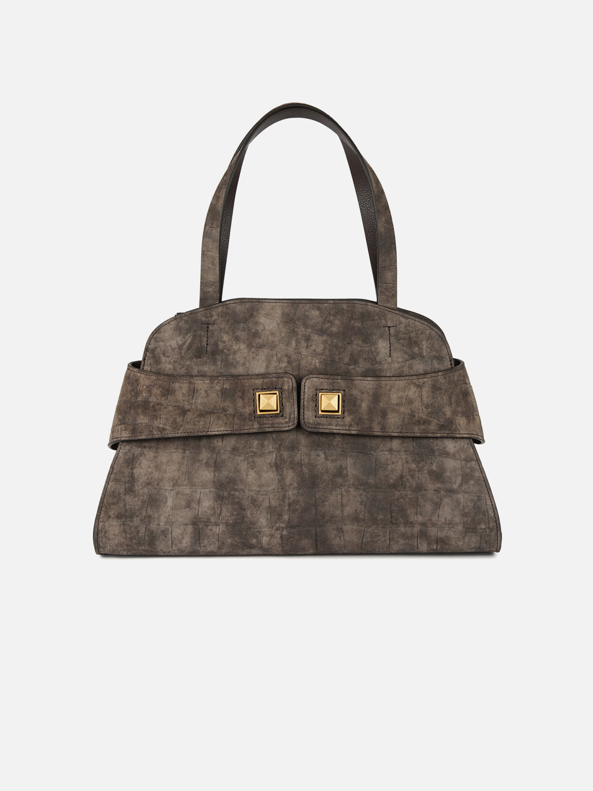 Front view of a structured taupe distressed suede handbag featuring subtle embossed tile patterns, twin top handles, a horizontal front strap, and two square gold-tone pyramid studs. Isolated on a seamless light grey background.