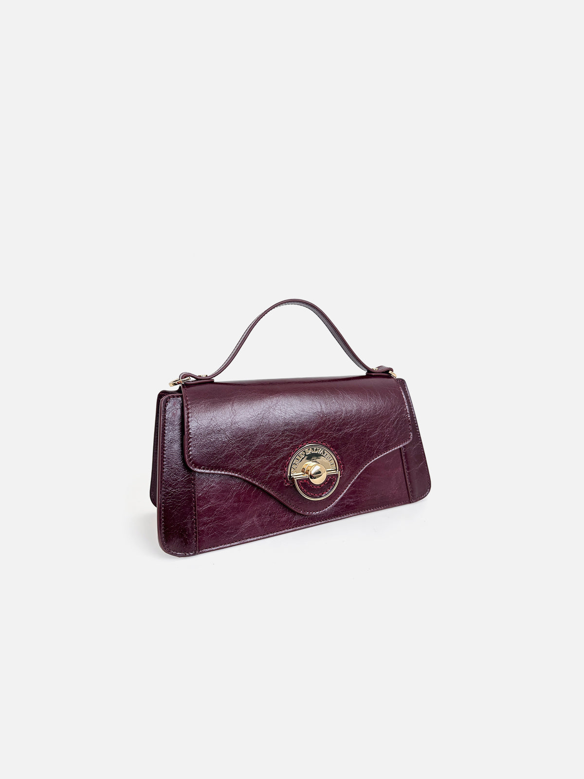 Three-quarter view of a luxury deep plum glossy leather top-handle bag featuring a contoured flap and signature round gold clasp.