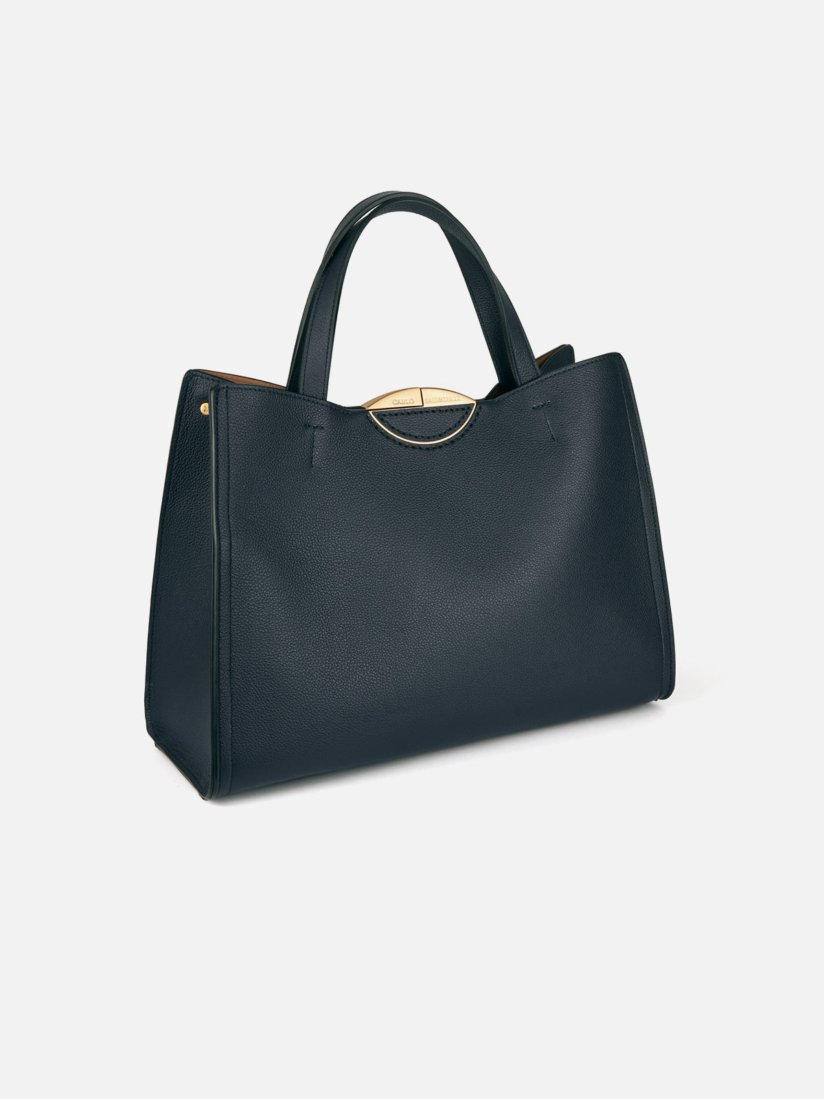 Three-quarter view of a luxury midnight blue grained leather tote bag with dual top handles, open multi-compartment design, and subtle gold-tone rim detail along the top edge.