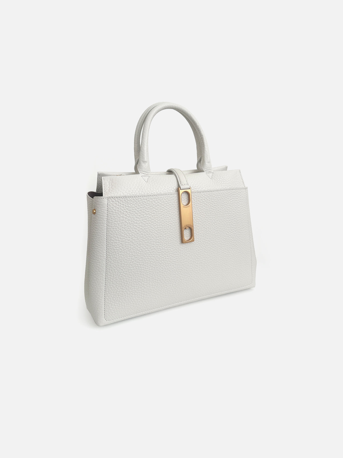 Three-quarter view of a luxury chalk white pebbled leather top-handle tote bag featuring dual rounded handles and a vertical leather strap with an elongated gold-tone metallic hardware detail.