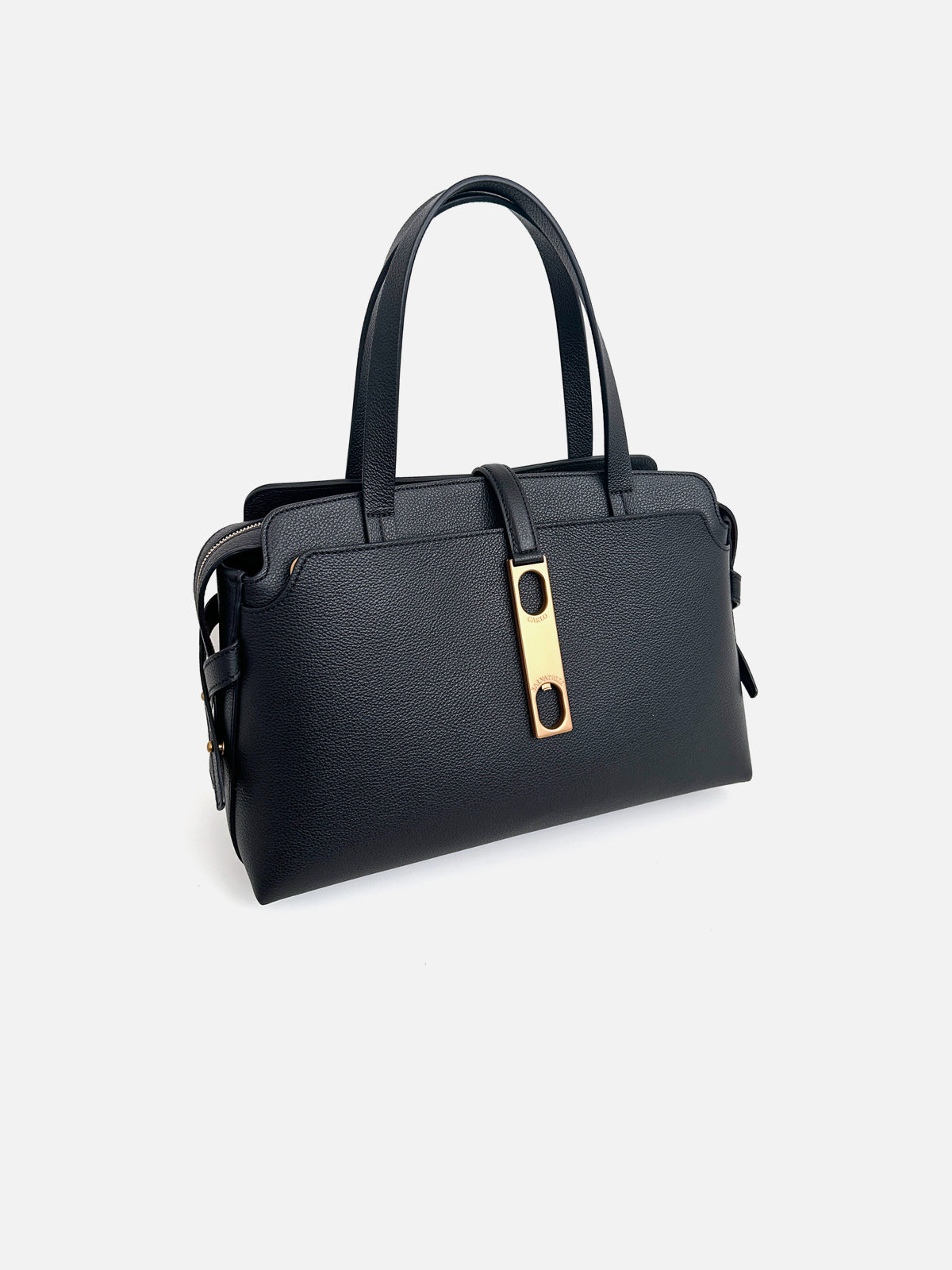 Three-quarter view of a luxury black saffiano leather top-handle tote bag featuring dual tall shoulder handles and a vertical leather tab with a signature gold-tone metallic buckle closure.